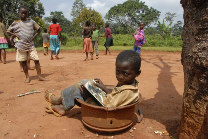 Malý chlapec v Kamerunu listuje Gorilími pohádkami. Foto © Miroslav Bobek, Zoo Praha